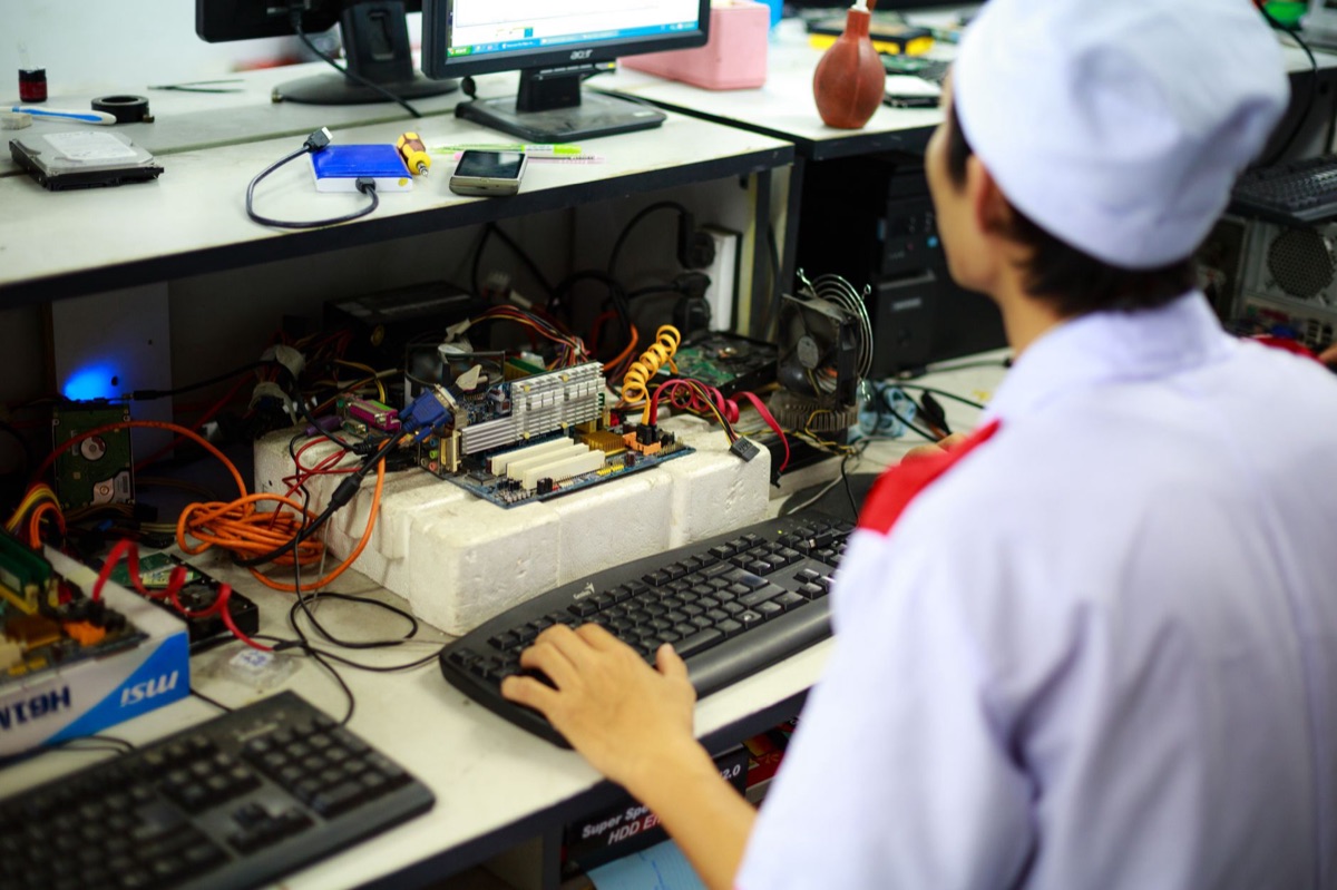 Technician monitors robot in medical tech room